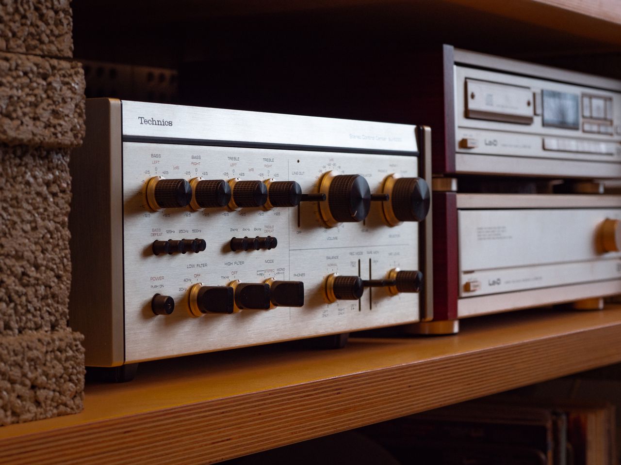 collection-01 Close-up of a retro stereo receiver with knobs on a shelf, exuding nostalgic vibes.